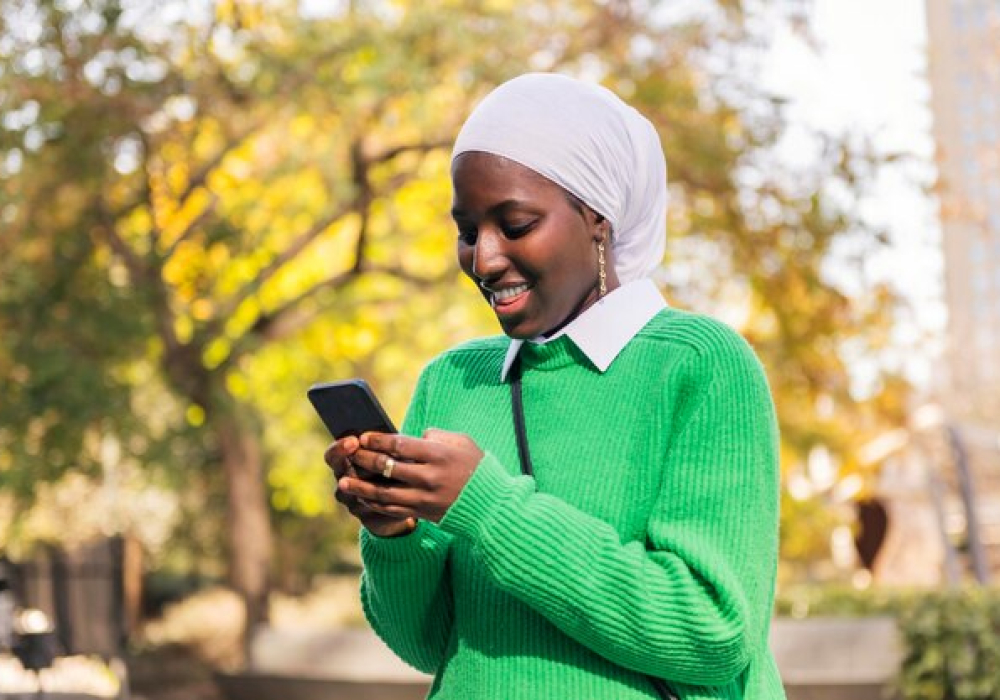 black-woman-smiling-happy-using-her-mobile-phone_362480-3766